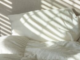 a bed with white sheets and white pillows