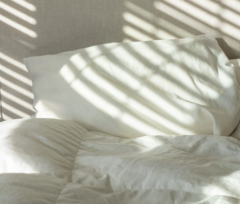a bed with white sheets and white pillows